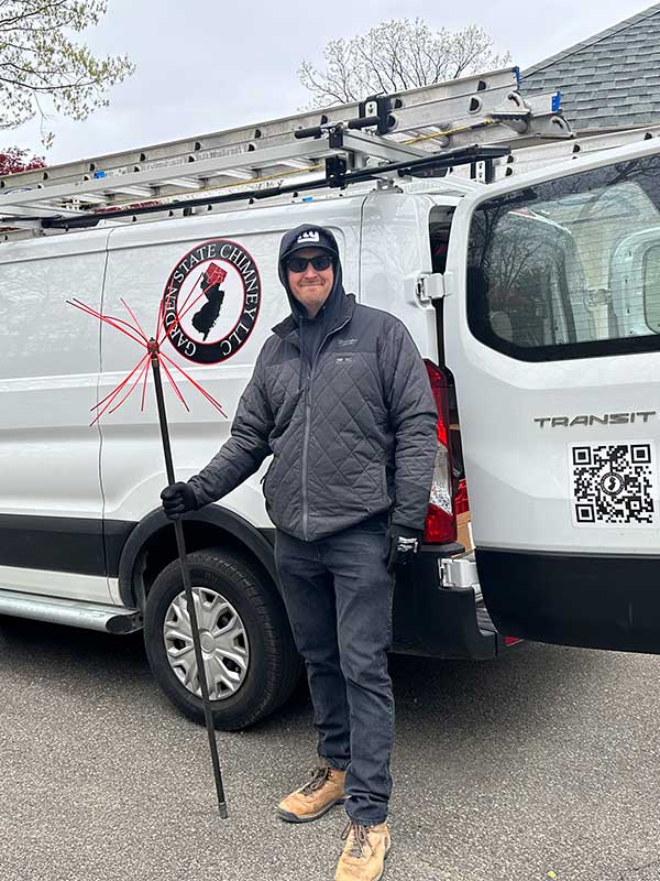 Garden State Chimney technician with sweeping brush